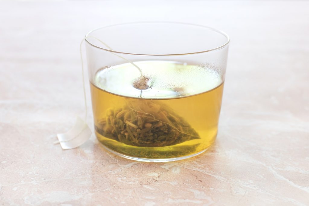 clear drinking glass with yellow herbal tea