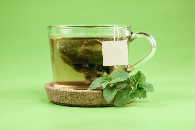 clear glass mug with green tea